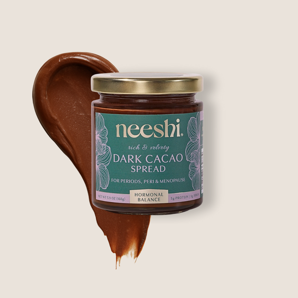 A jar of Neeshi dark cacao spread on a beige background